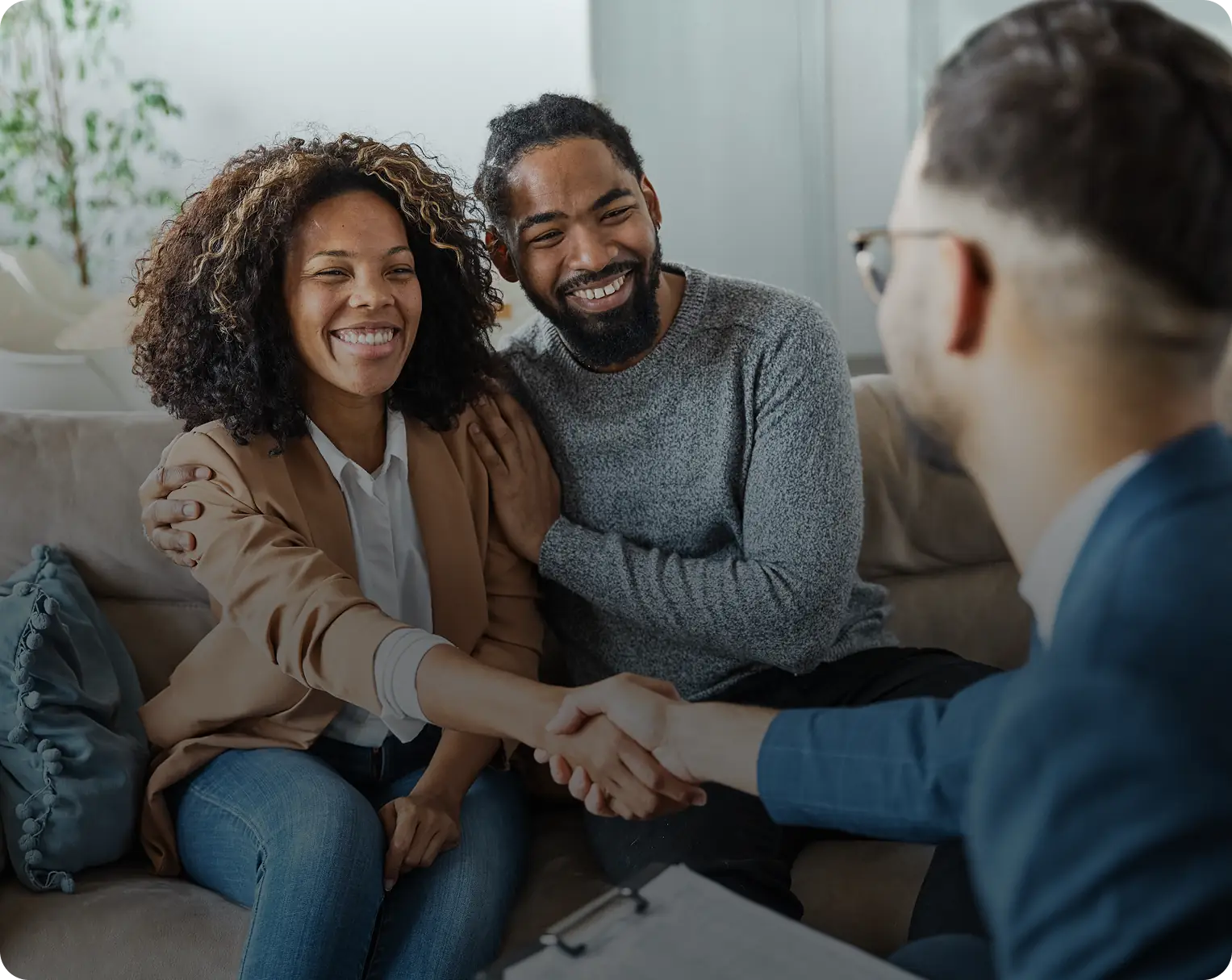 Couple happily shaking hands with professional.